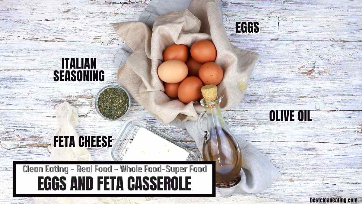 Top view of eggs in a basket, a bottle of olive oil, a dish of feta cheese, and Italian seasoning on a wooden surface. Text reads "Clean Eating - Real Food - Whole Food - Super Food. Eggs and Feta Casserole.