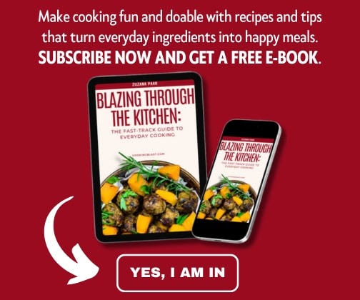Tablet and phone display the cover of a cookbook titled "Blazing Through The Kitchen." Text above offers a free e-book subscription for cooking tips; "YES, I AM IN" button below.