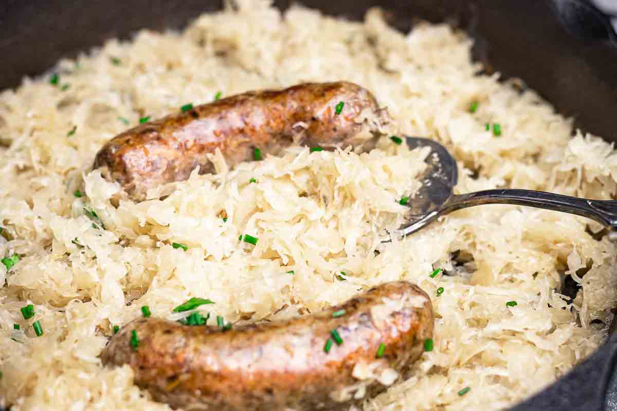 Sausage links with sauerkraut in skillet.
