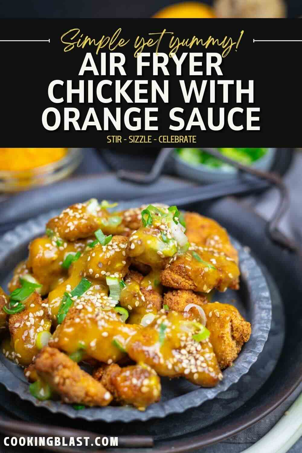 A plate of air fryer chicken pieces topped with orange sauce, chopped green onions, and sesame seeds, served on a dark dish.