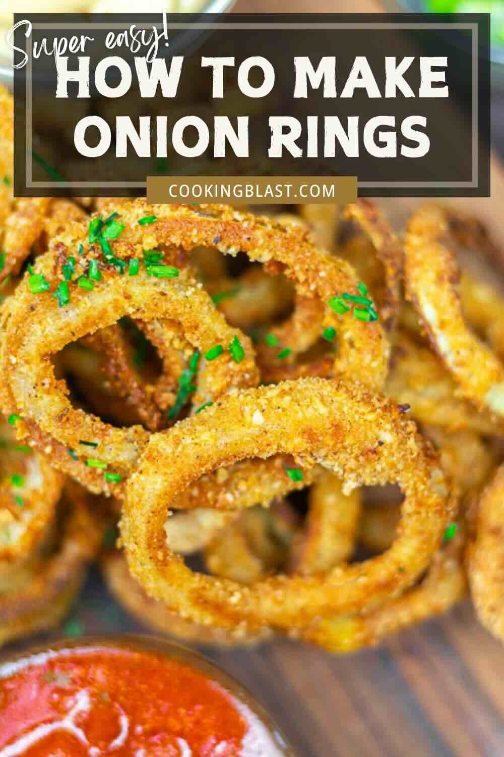 A plate of crispy, golden-brown onion rings garnished with chopped chives, with a bowl of red dipping sauce in the foreground. Text overlay: "How to Make Onion Rings.