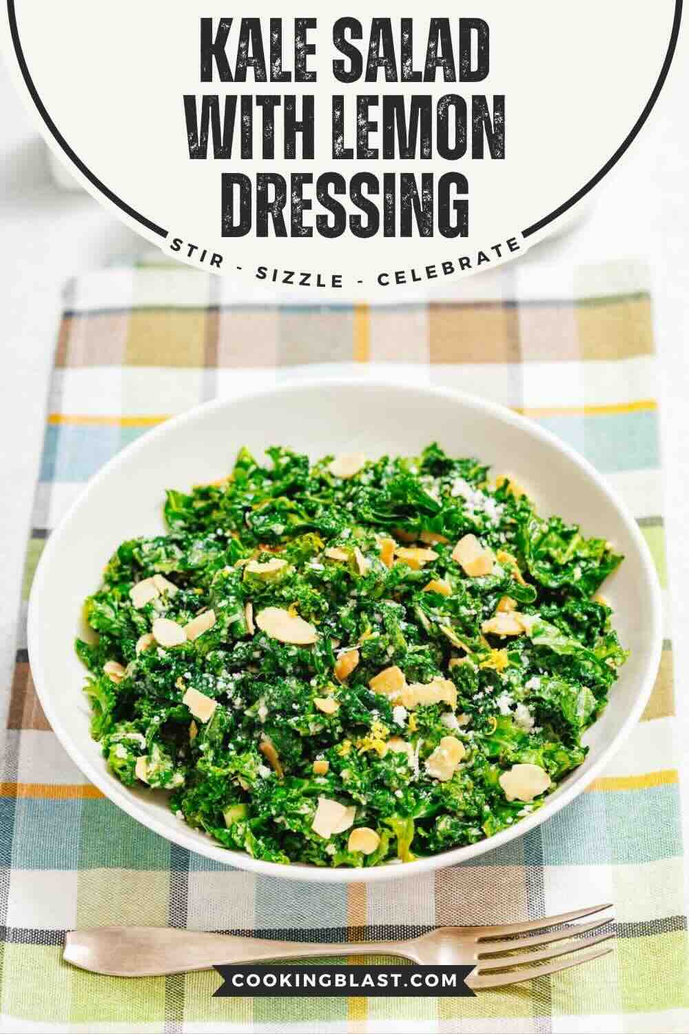 A bowl of kale salad topped with sliced almonds and a lemon dressing sits on a plaid tablecloth next to a fork.