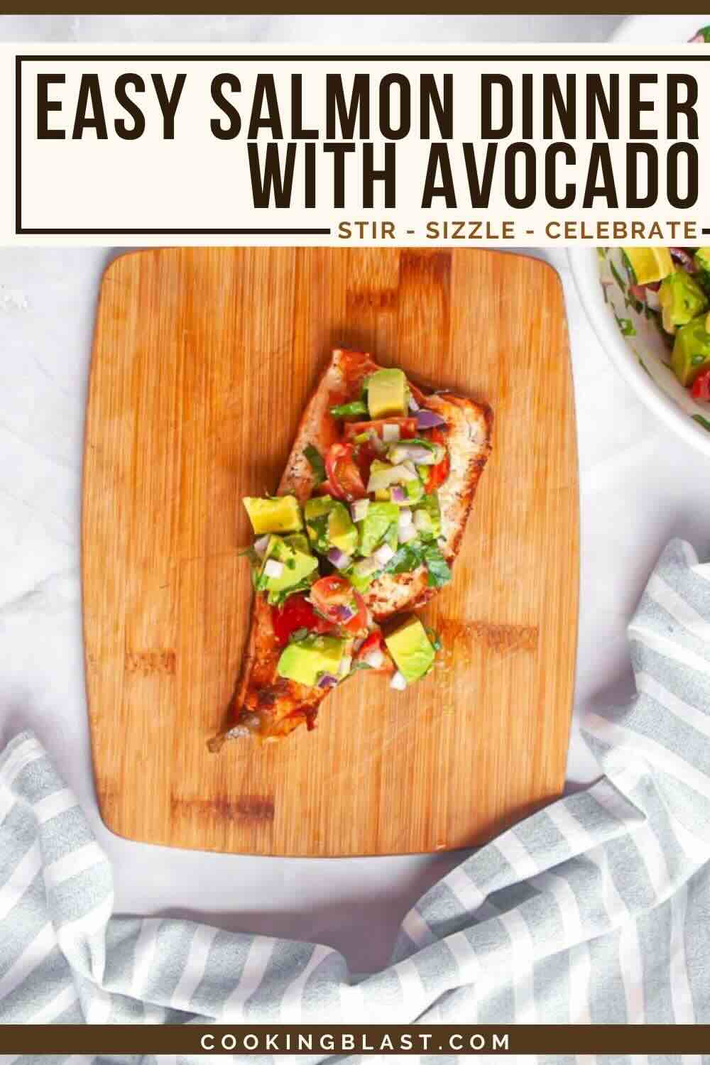 A cooked salmon fillet topped with diced avocado and vegetables sits on a wooden cutting board, with a striped cloth and a bowl of salad nearby.