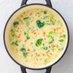 Creamy broccoli and carrot soup in a dark Dutch oven.