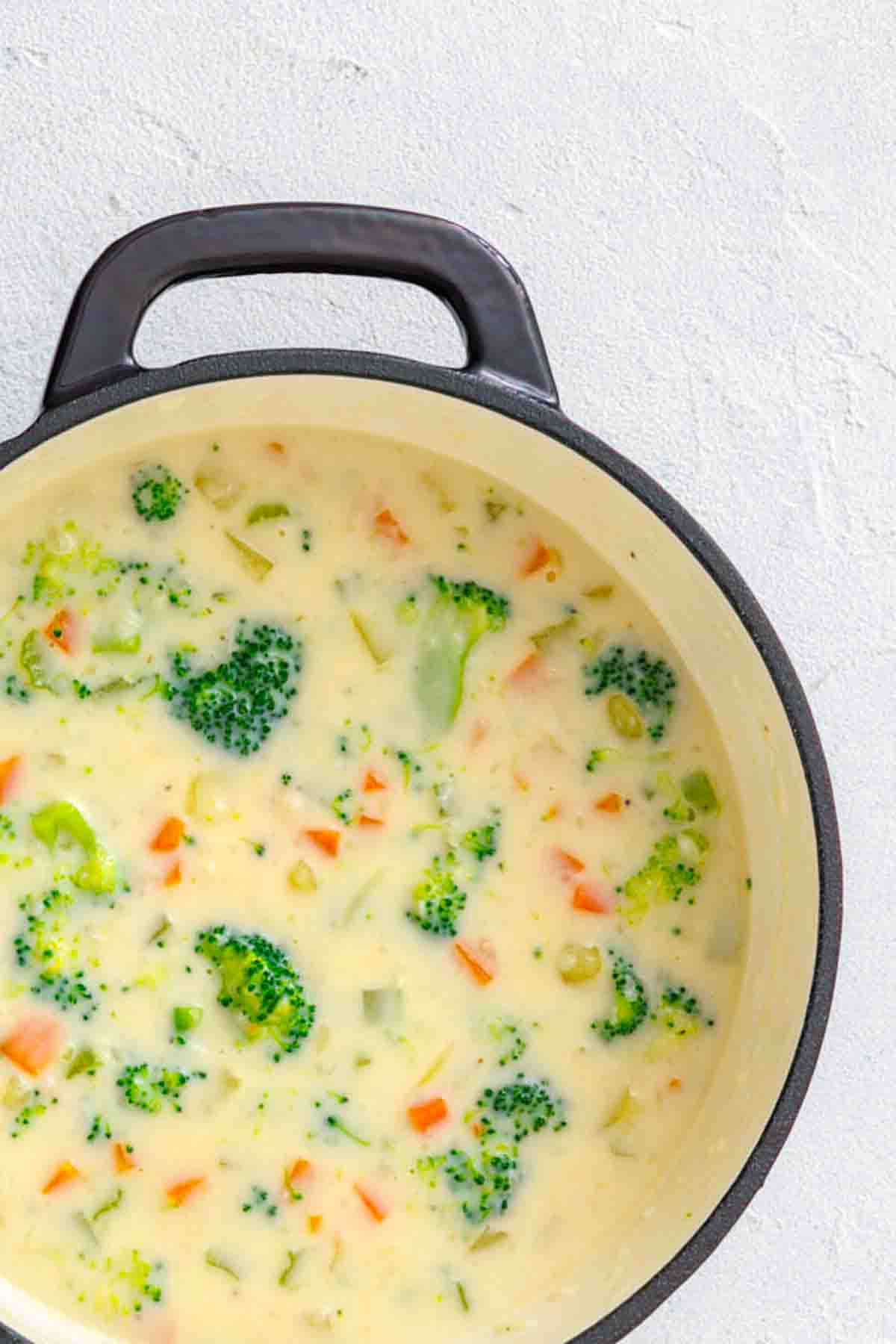 A pot of creamy broccoli and carrot soup.